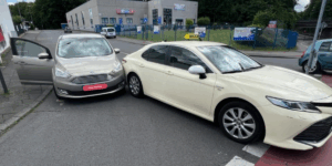 Unfallstelle in Köln: Ford-Fahrzeug beschädigt das Heck eines Toyota Camry Taxis – deutlicher Unfallschaden dokumentiert